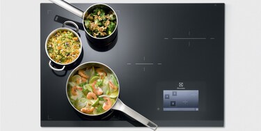 Trois casseroles dans la FreeZone d'une table à induction Infinite Combi par Electrolux