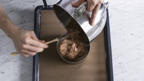 Pâtissier versant la génoise dans un cercle à pâtisserie