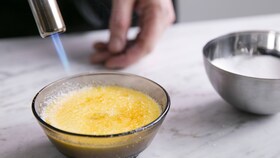 Pâtissier caramélisant le sucre de la crème brûlée au chalumeau