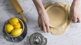 Pâtissier Electrolux remplissant avec attention le moule de l'appareil à tarte