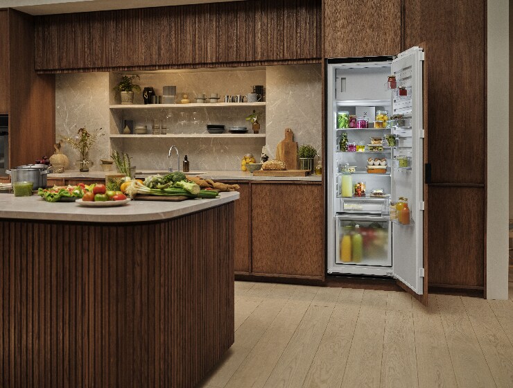 Vue de la cuisine avec un réfrigérateur ouvert à l’arrière-plan.